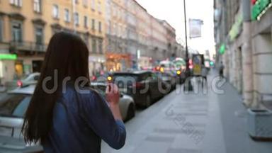 在街上看到一个女孩，把她的头发倒回去。 背景模糊，城市灯光，汽车，慢莫，稳定射击